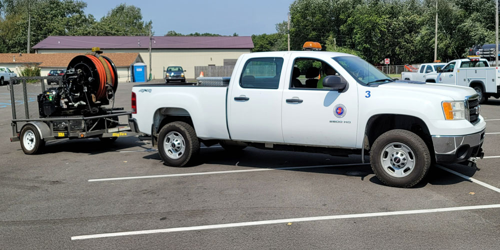 Merrillville Conservancy District pickup truck towing a trailer-mounted sewer cleaning unit